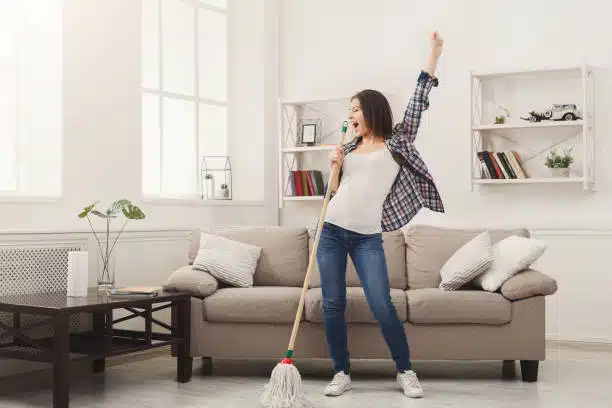 Hacks to Create a cleaning Schedule - A woman with a mop singing