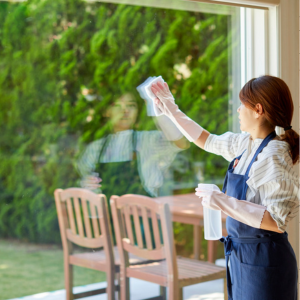 Fall Cleaning Checklist -A woman cleaning a glass window